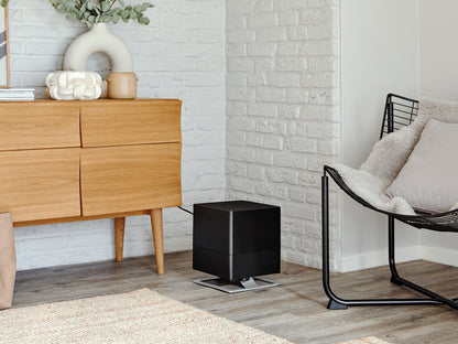 Stadler Form Oskar humidifier in black next to a sideboard